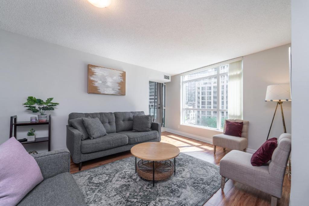 a living room with a couch and chairs and a table at Spacious 2 Bedroom plus Den, 2 Bath, Sleeps 5 with Balcony and Lakeview Downtown Toronto Condo in Toronto