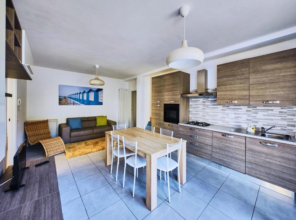 a kitchen and living room with a wooden table and chairs at Affitti Brevi Liguria - Casamare in Varazze