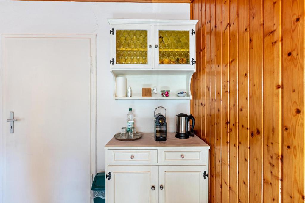 a kitchen with white cabinets and a coffee maker on a counter at Haus Am Bühl in Schönau im Schwarzwald