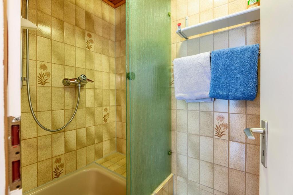 a bathroom with a tub and a shower with towels at Haus Am Bühl in Schönau im Schwarzwald