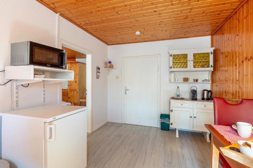 a kitchen with white cabinets and a wooden ceiling at Haus Am Bühl in Schönau im Schwarzwald