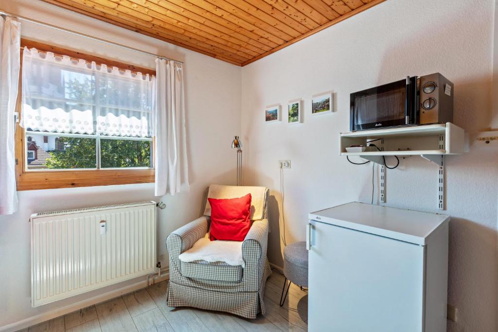 a small living room with a chair and a television at Haus Am Bühl in Schönau im Schwarzwald