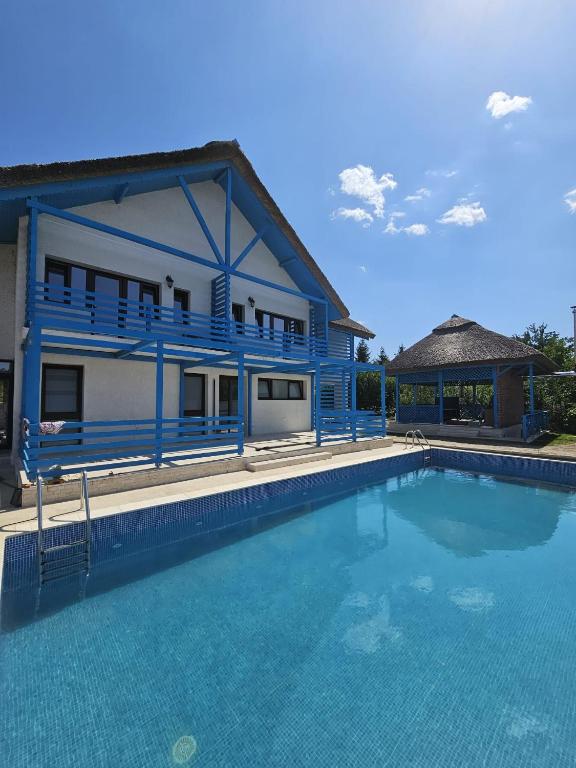 a blue house with a swimming pool in front of it at La Belle Mouette in Somova