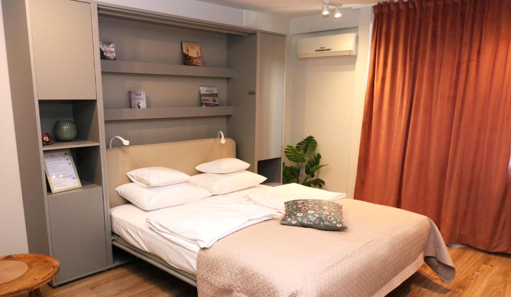 Un dormitorio con una cama con sábanas y almohadas blancas. en Falcon Apartment Center 2 Metro Złote Tarasy, en Varsovia