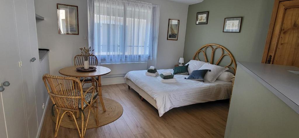 une chambre avec un lit, une table et une fenêtre dans l'établissement studio situé entre port et plage, à Les Sables-dʼOlonne