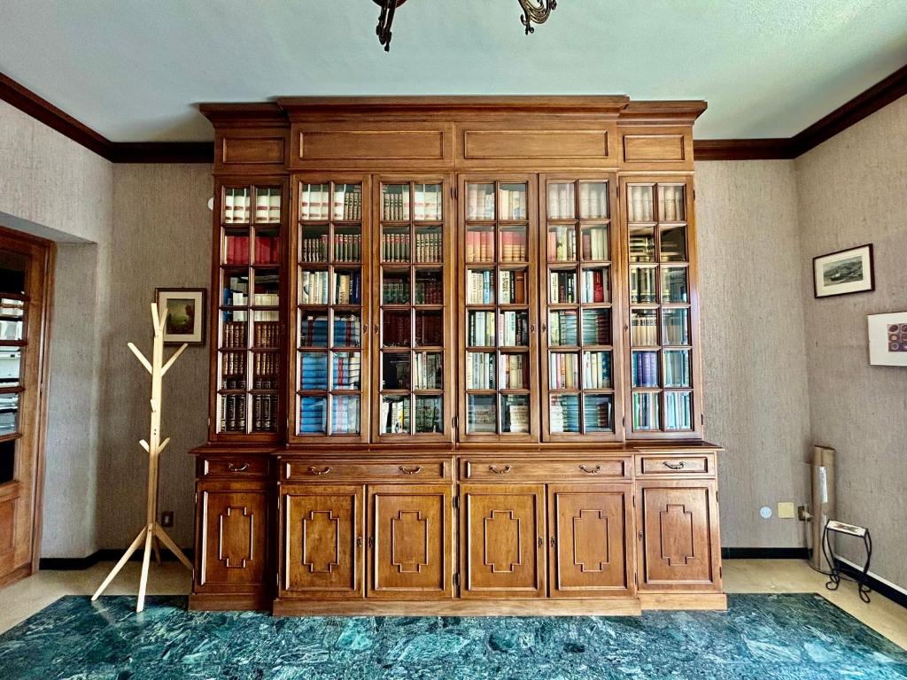 a large wooden cabinet with glass doors in a room at Casa Cele centro città vista mare in Ventimiglia