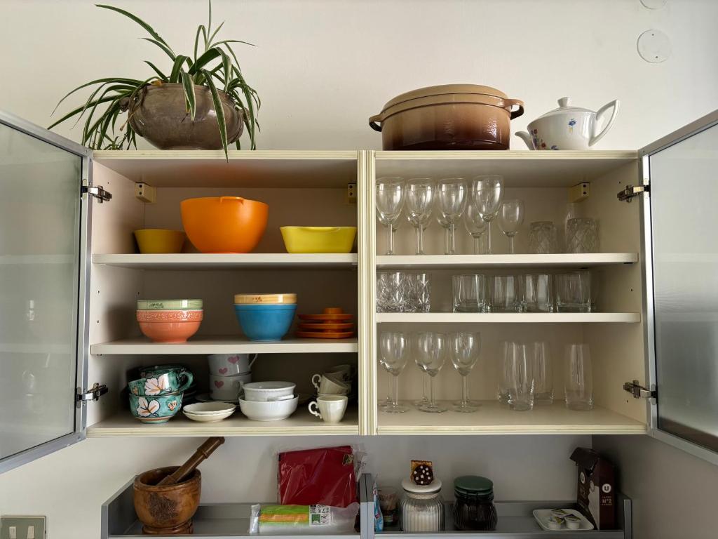 a kitchen cabinet filled with glasses and dishes at Casa Cele centro città vista mare in Ventimiglia
