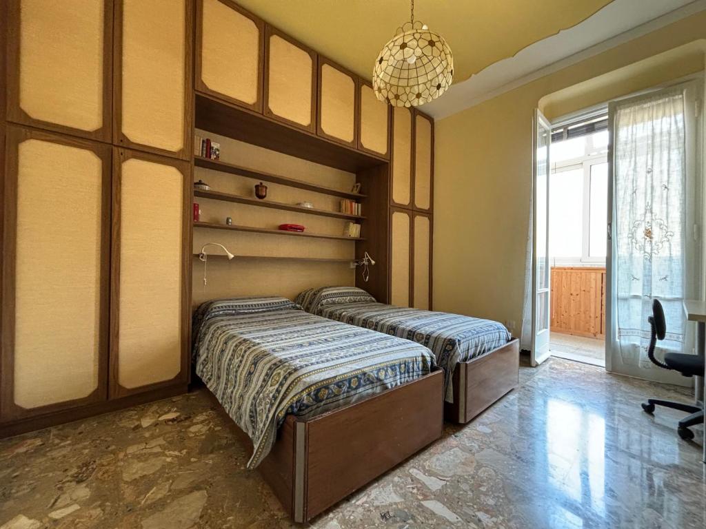 a bedroom with two beds and a chandelier at Casa Cele centro città vista mare in Ventimiglia