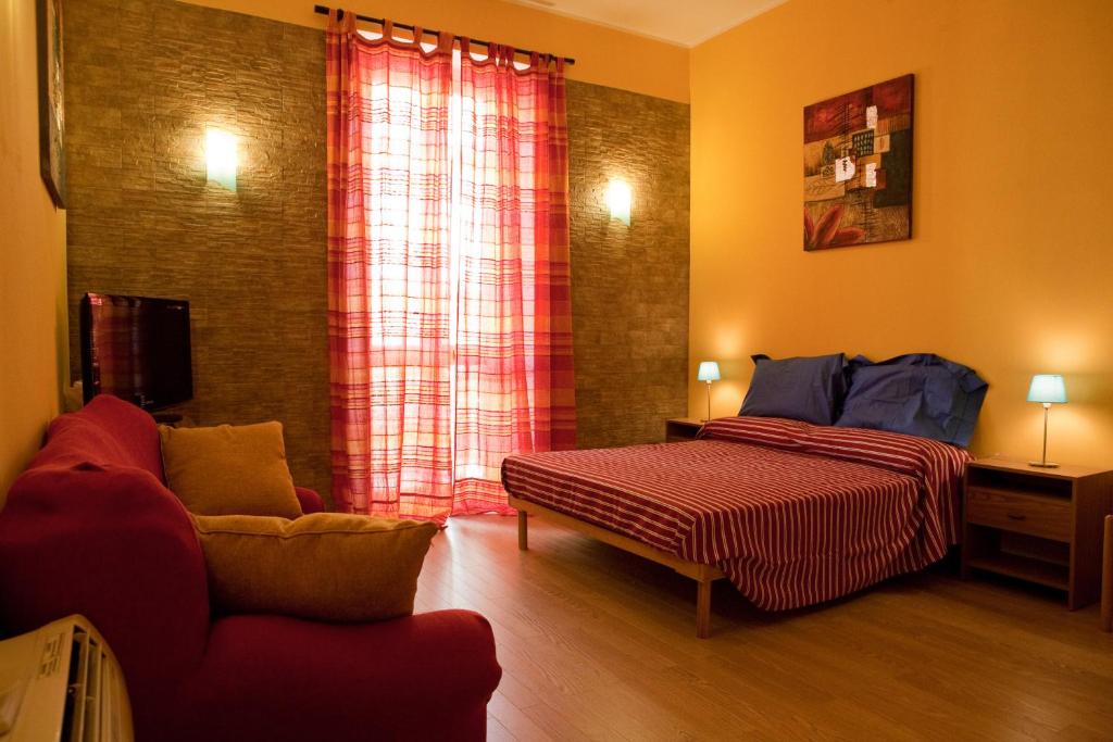 ein Schlafzimmer mit einem Bett und einem Sofa in einem Zimmer in der Unterkunft Abba De Mar in Alghero