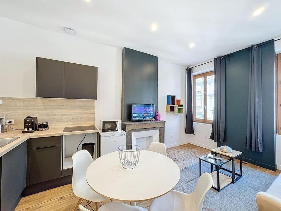 - une cuisine avec une table et des chaises blanches dans la chambre dans l'établissement My home Lafayette 4, à Lyon