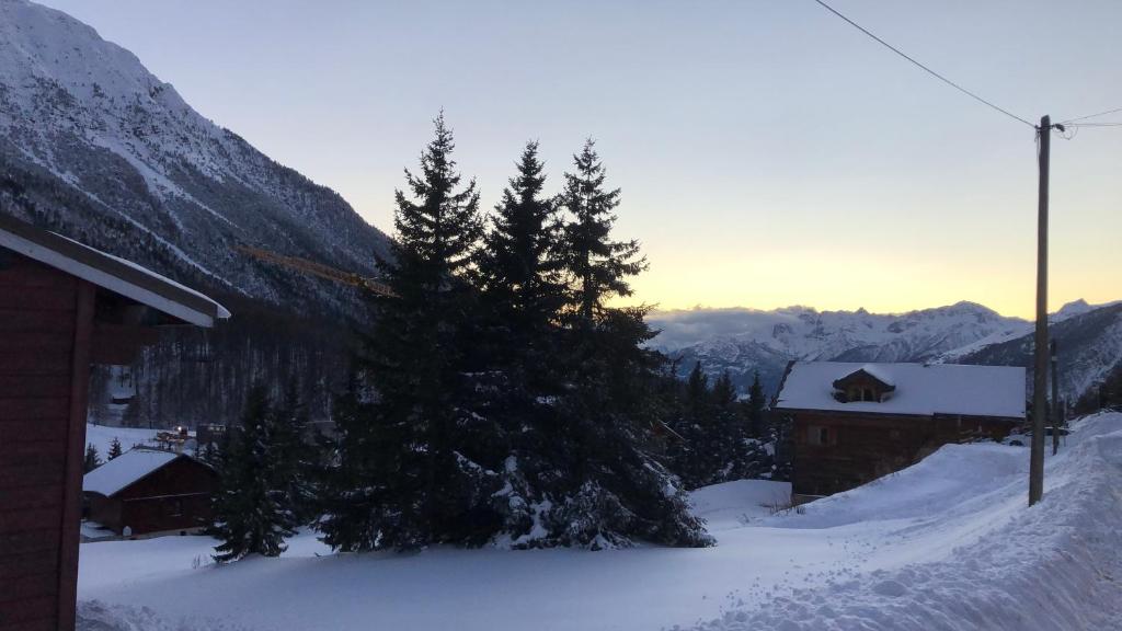 una casa en la nieve con árboles y una montaña en Casa vacanze Monginevro, en Montgenèvre