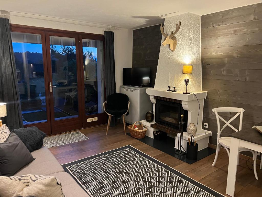 a living room with a fireplace and a tv at Location Studio avec Jardin en Hameau II in Gréolières