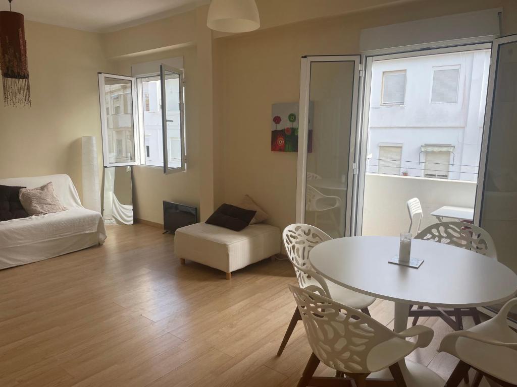 Una sala de estar con una mesa y sillas blancas. en Cozy Appartement - Lumineux 3 pièces, à côté du Jardin de Turia, en Valencia
