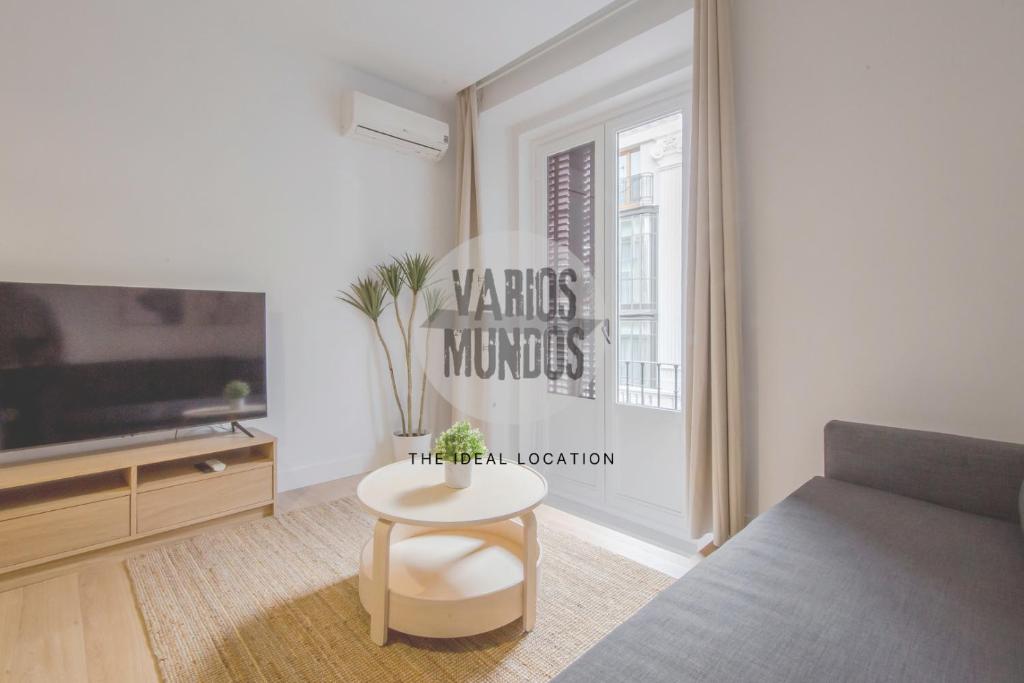 a living room with a couch and a table and a tv at Tu balcón en Madrid para 3, Carretas 25 in Madrid