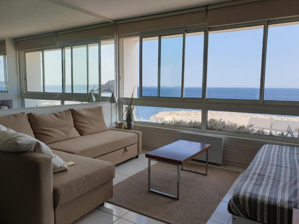 a living room with a couch and a table at Appart vue d'exception sur la mer in Bandol