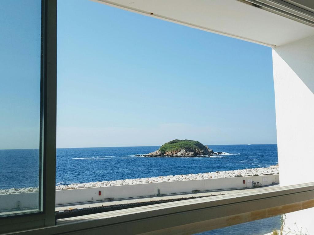 a window view of a small island in the ocean at Appart vue d'exception sur la mer in Bandol