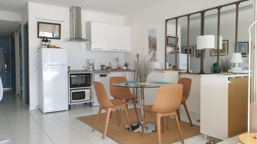 a kitchen with a table and chairs and white appliances at Appart vue d'exception sur la mer in Bandol