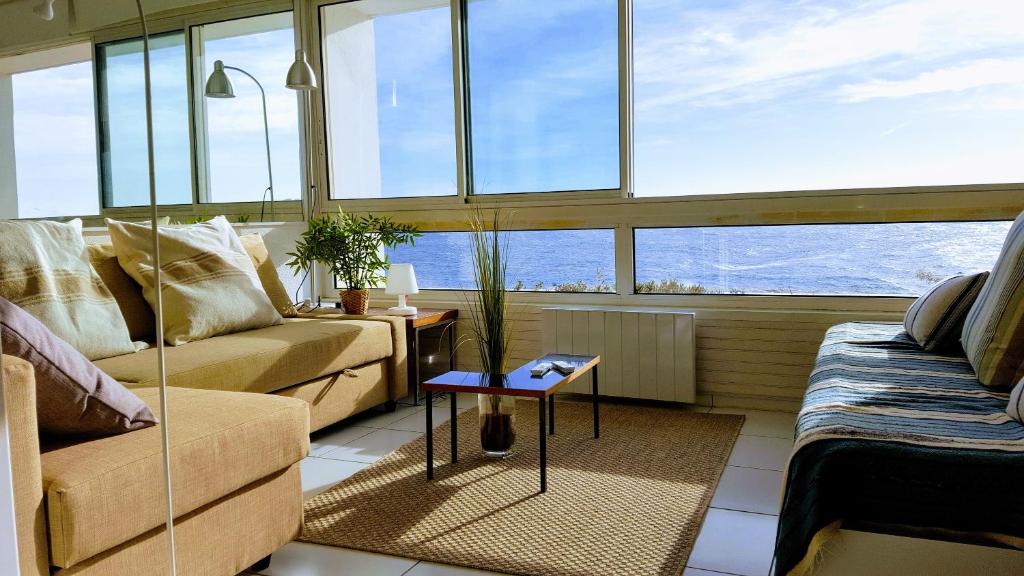 a living room with a couch and a table at Appart vue d'exception sur la mer in Bandol