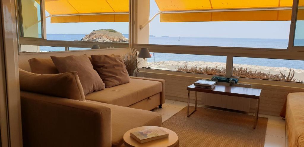 a living room with a couch and a view of the ocean at Appart vue d'exception sur la mer in Bandol