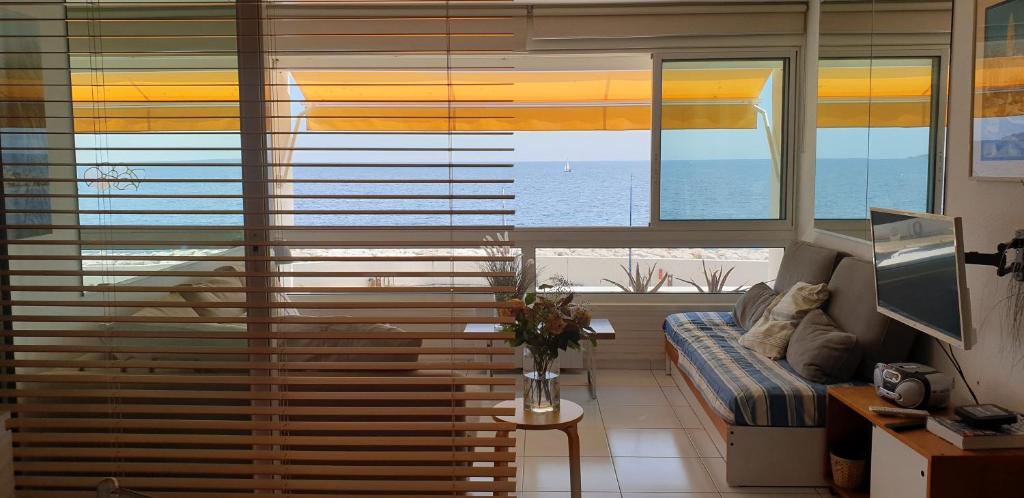 a living room with a large window with blinds at Appart vue d'exception sur la mer in Bandol