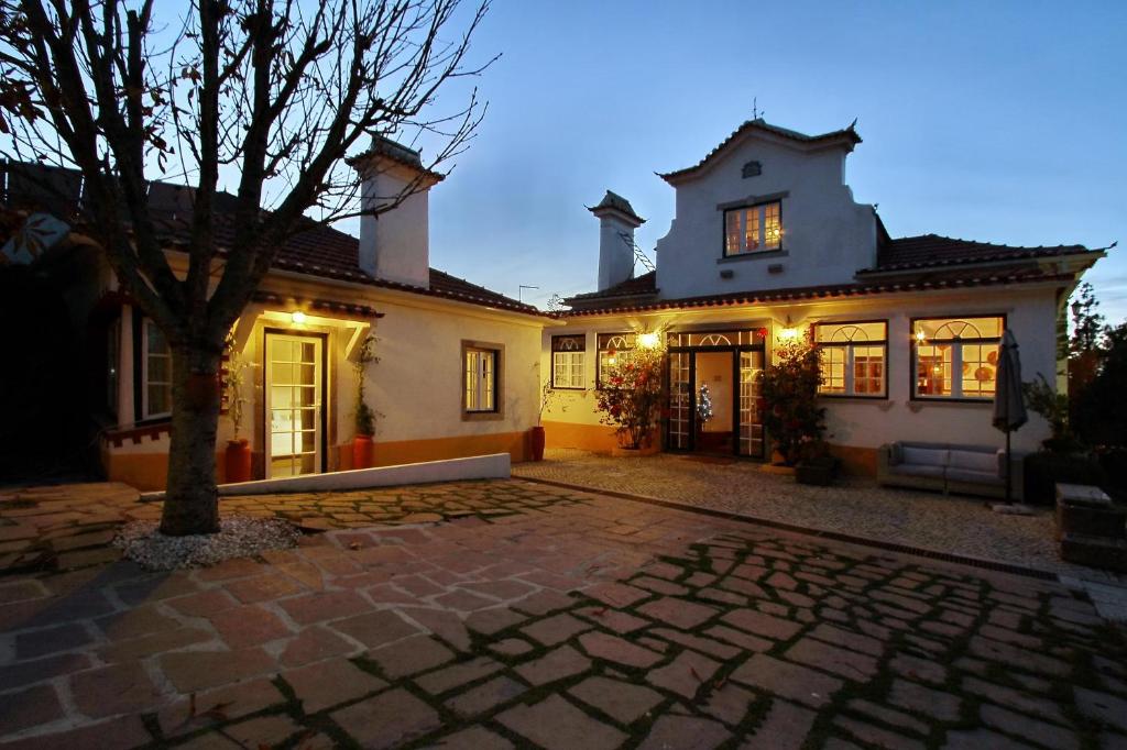 uma casa com uma entrada de pedra em frente em Villa das Rosas em Sintra