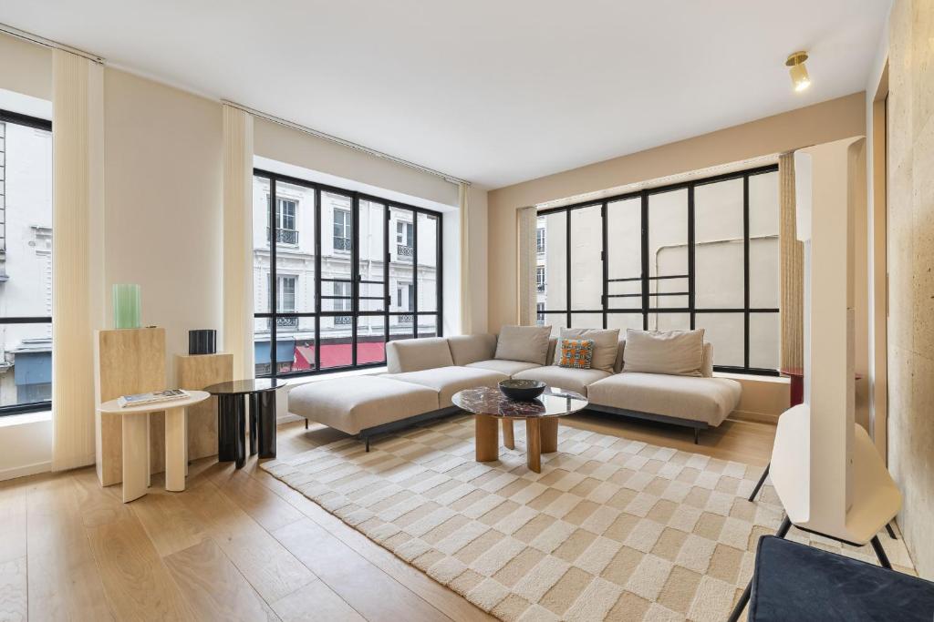 un salon avec un canapé et quelques fenêtres dans l'établissement La Grande Ecurie, à Paris