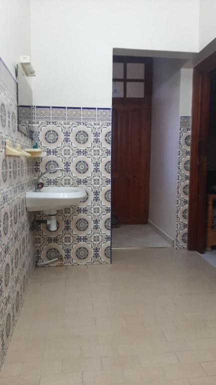 アウリールにあるAwrirのタイル張りの壁、洗面台付きのバスルーム