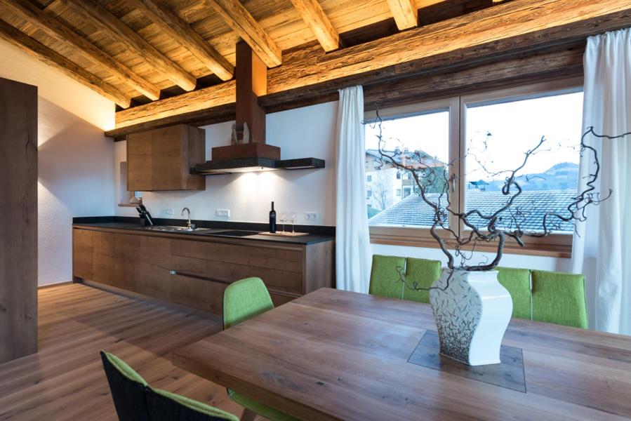 eine Küche mit einem Holztisch mit einer Vase darauf in der Unterkunft Chalet Wegmacher in Kirchberg in Tirol