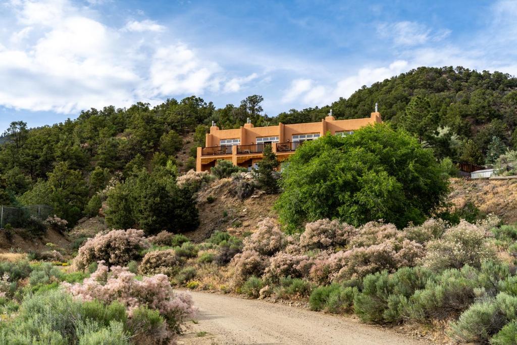 a house on top of a hill with a dirt road at Side-by-side Adobes, 9 Mi To Taos Ski Valley in Valdez