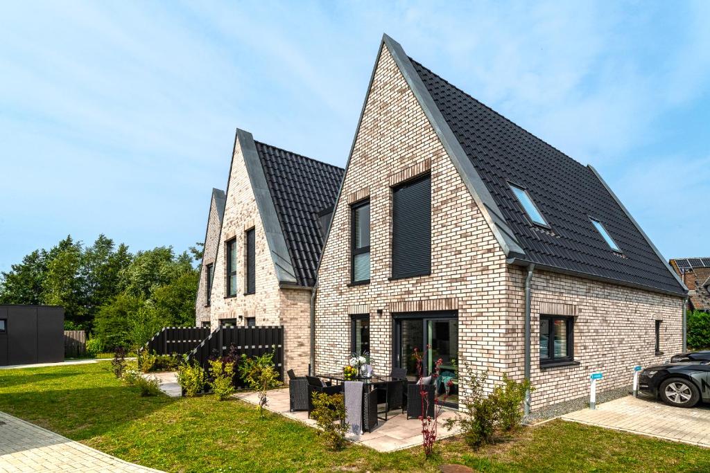 a large brick house with a black roof at Ferienhaus Donnerkeil Fehmarn in Fehmarn