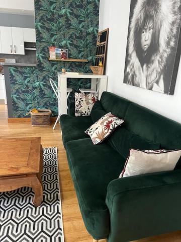 un salon avec un canapé vert et une table dans l'établissement LE BERCHON classé trois épis, à Nay