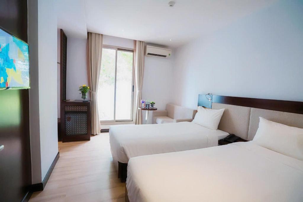 Postel nebo postele na pokoji v ubytování Dana Pearl Danang Hotel By HOS