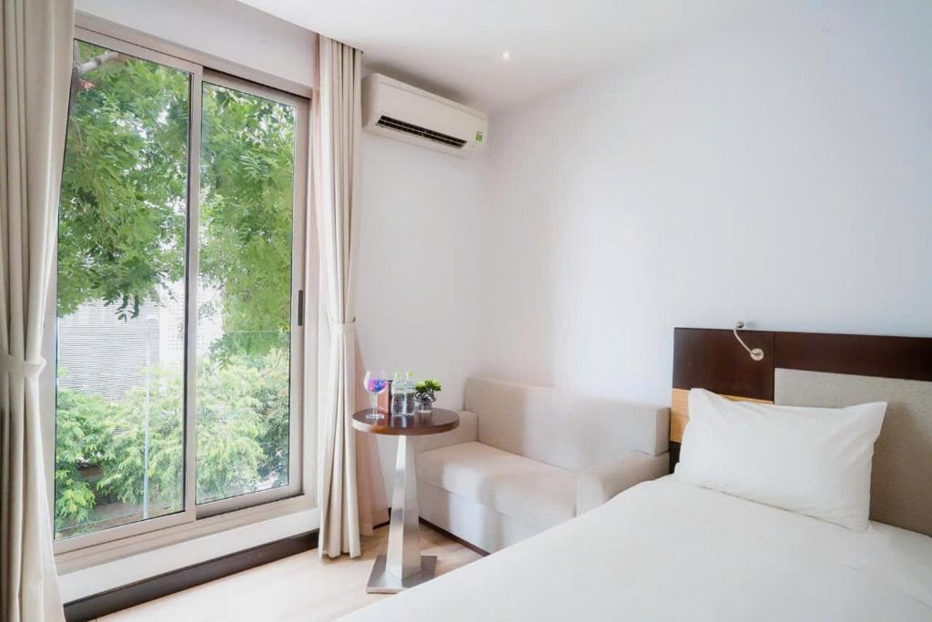 Postel nebo postele na pokoji v ubytování Dana Pearl Danang Hotel By HOS