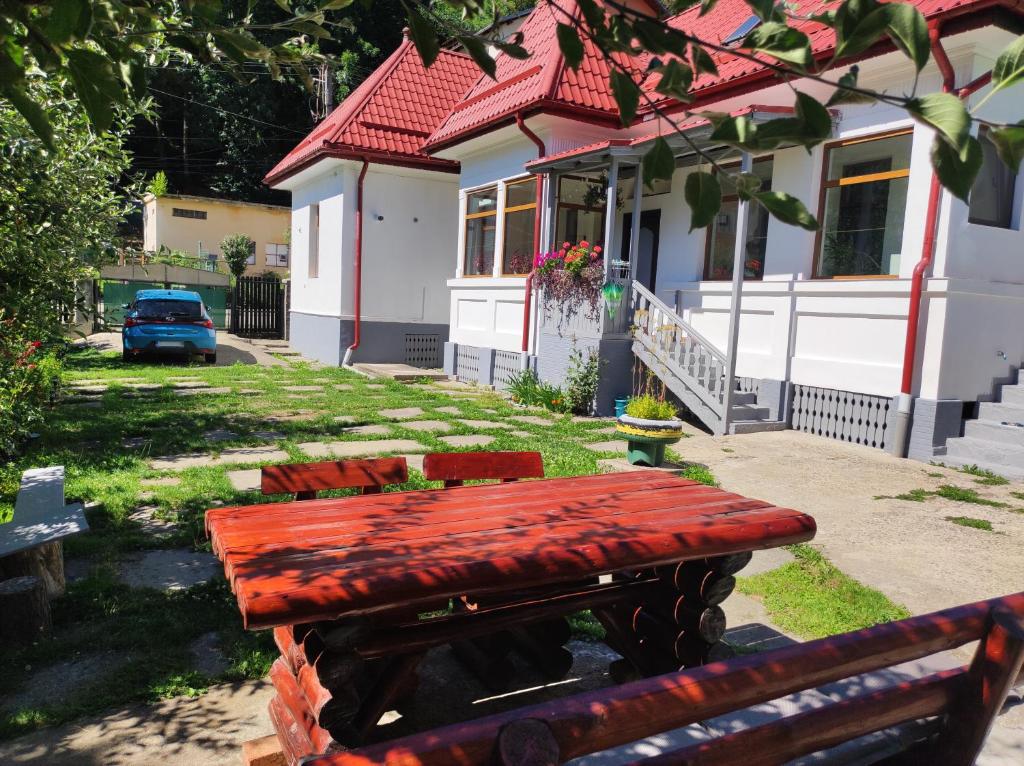 a red bench in front of a house at Little Bear Busteni in Buşteni