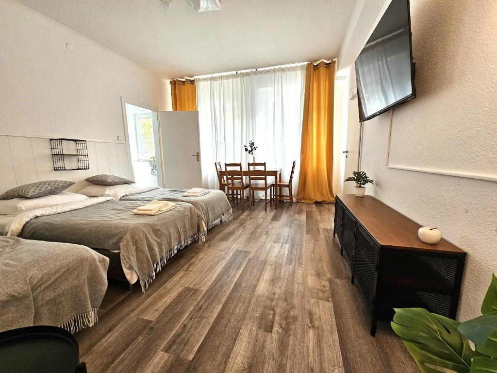 a hotel room with two beds and a table and chairs at Spacious House in Düsseldorf