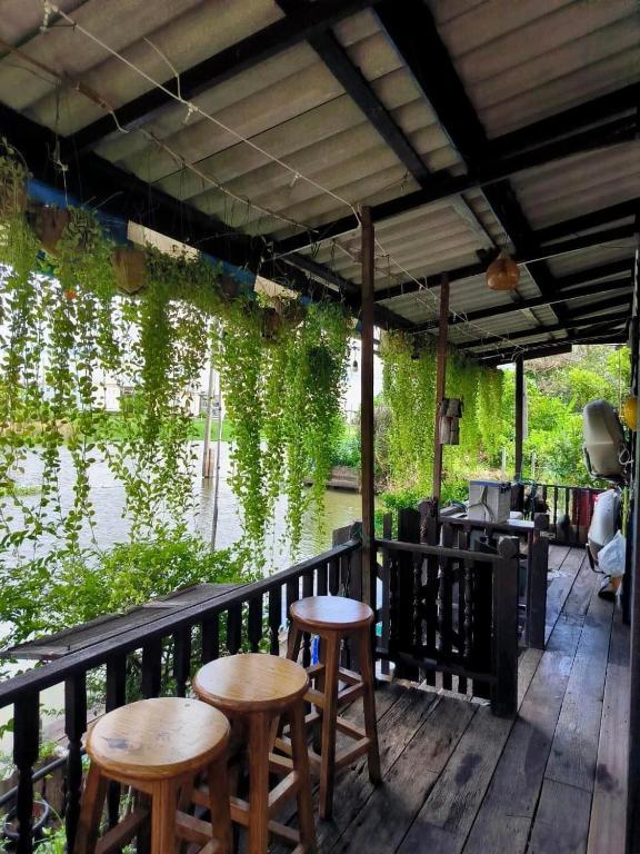 a porch with two stools and a table and chairs at Croc Camp in Lat Krabang