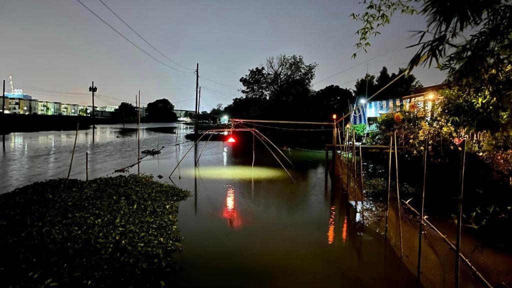 a car driving down a flooded street at night at Croc Camp in Lat Krabang