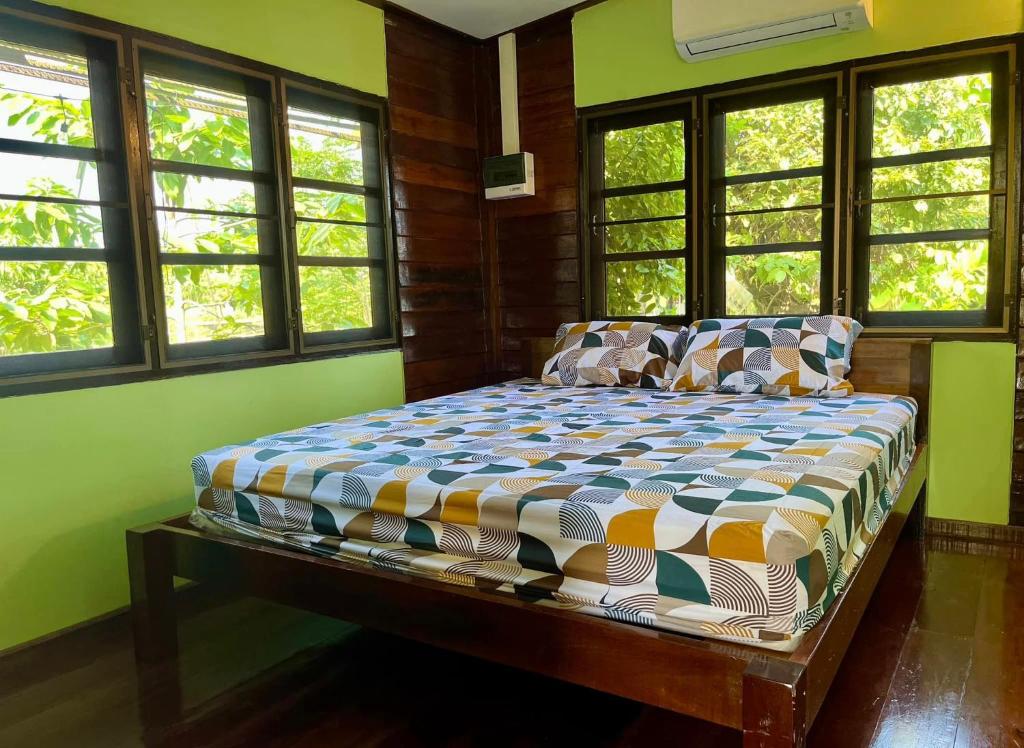 a bedroom with a bed in a room with windows at Croc Camp in Lat Krabang