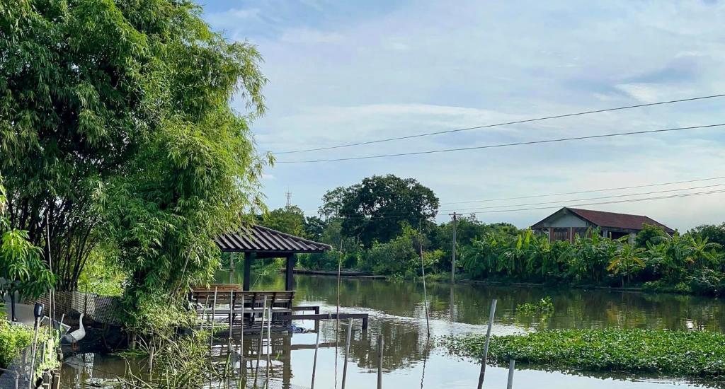 a view of a river with a table and a hut at Croc Camp in Lat Krabang