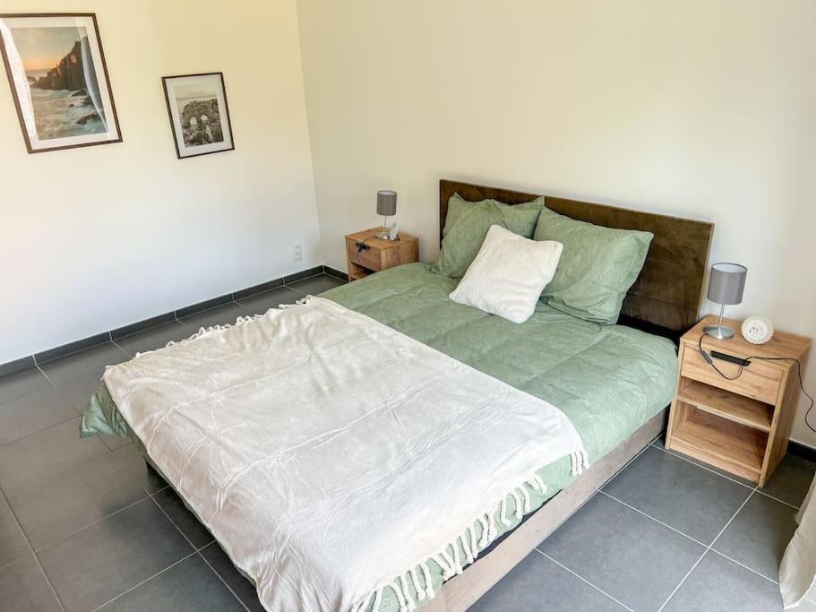 een slaapkamer met een groot bed en een nachtkastje bij Charmant Logement Brugelette Proche de Pairi Daiza in Brugelette