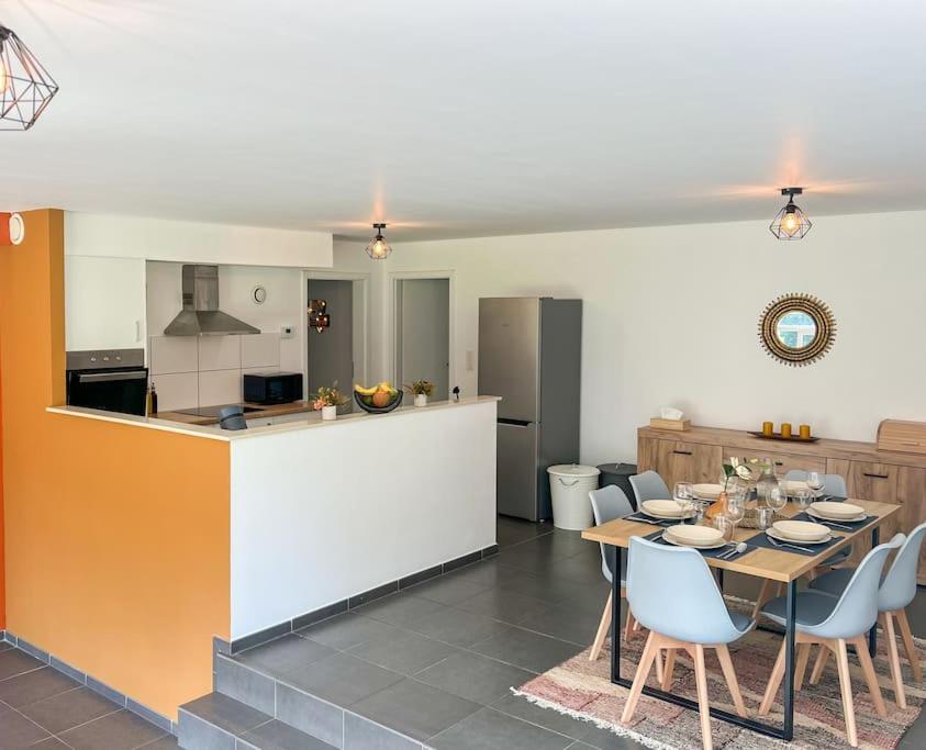 een keuken en eetkamer met een tafel en stoelen bij Charmant Logement Brugelette Proche de Pairi Daiza in Brugelette