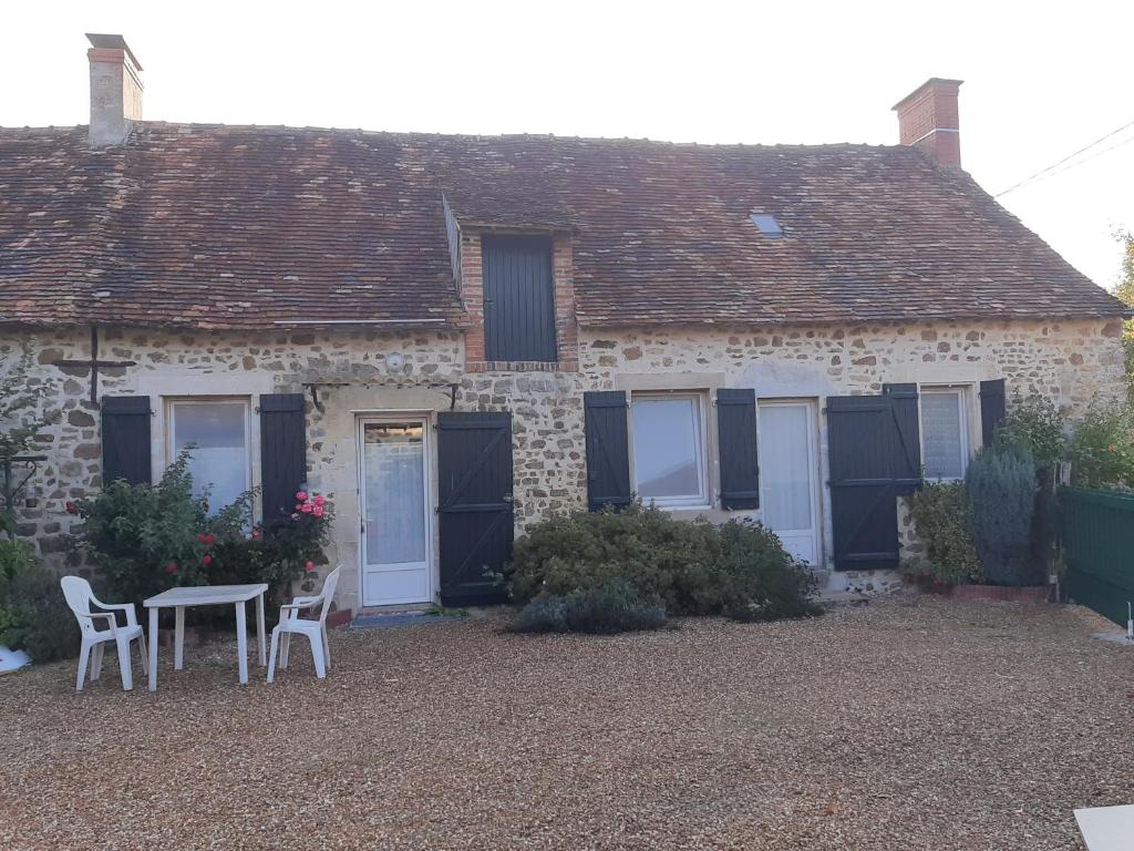 une maison avec une table et des chaises devant dans l'établissement petit gite l'ecotay, à Saint-Symphorien