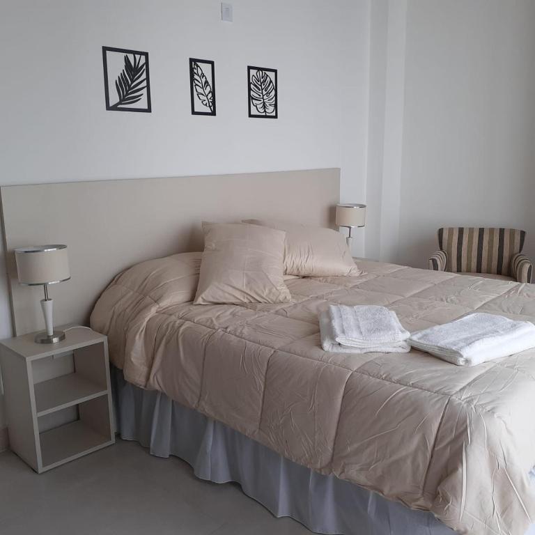 a bed with two towels on it in a bedroom at Monoambientes Magus in Junín