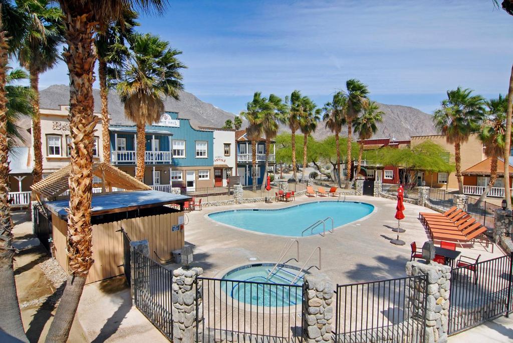 a swimming pool with palm trees and a resort at Palm Canyon Hotel and RV Resort in Borrego Springs