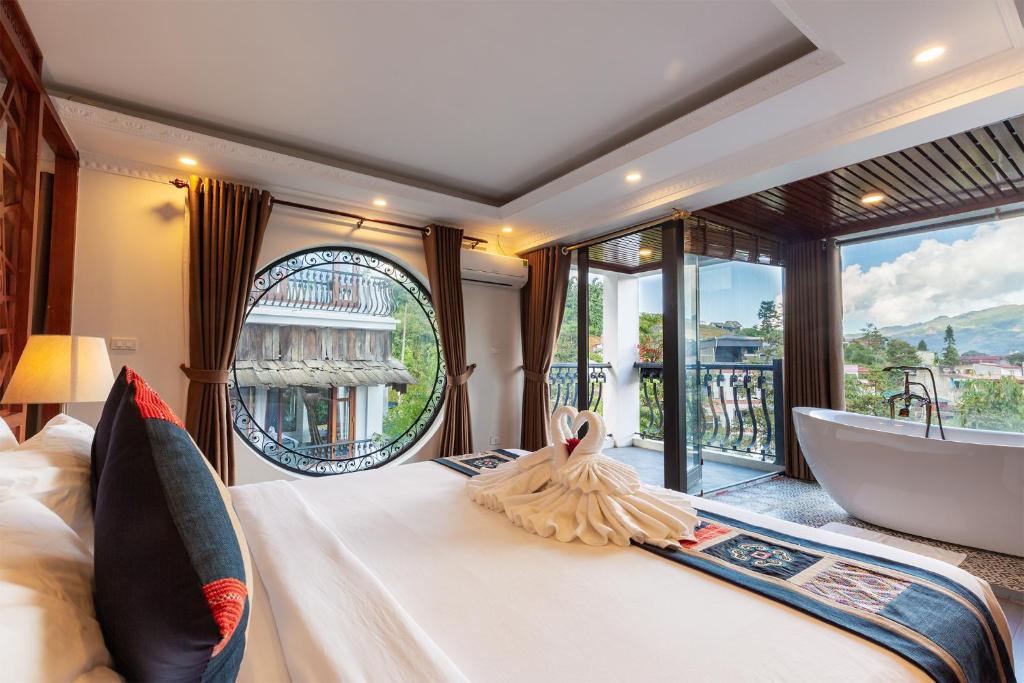 a bedroom with a tub and a bed with a view at Green Villa Sapa in Sapa