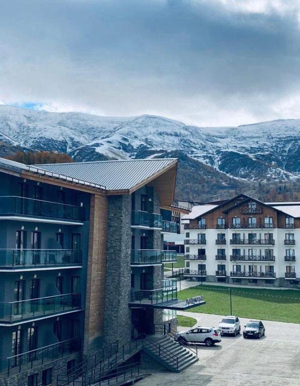 un edificio con auto parcheggiate in un parcheggio di Crystal Resort a Bakuriani