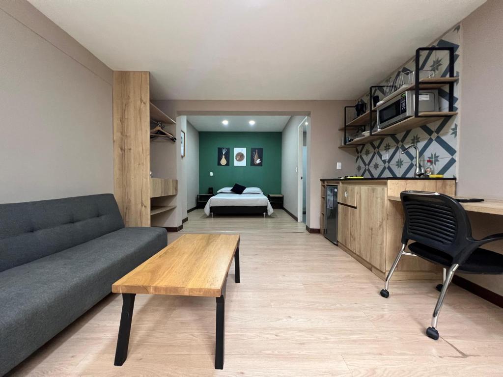 a living room with a couch and a bed at Económico alojamiento en Medellín por días - A102 By Roots Rentals in Medellín