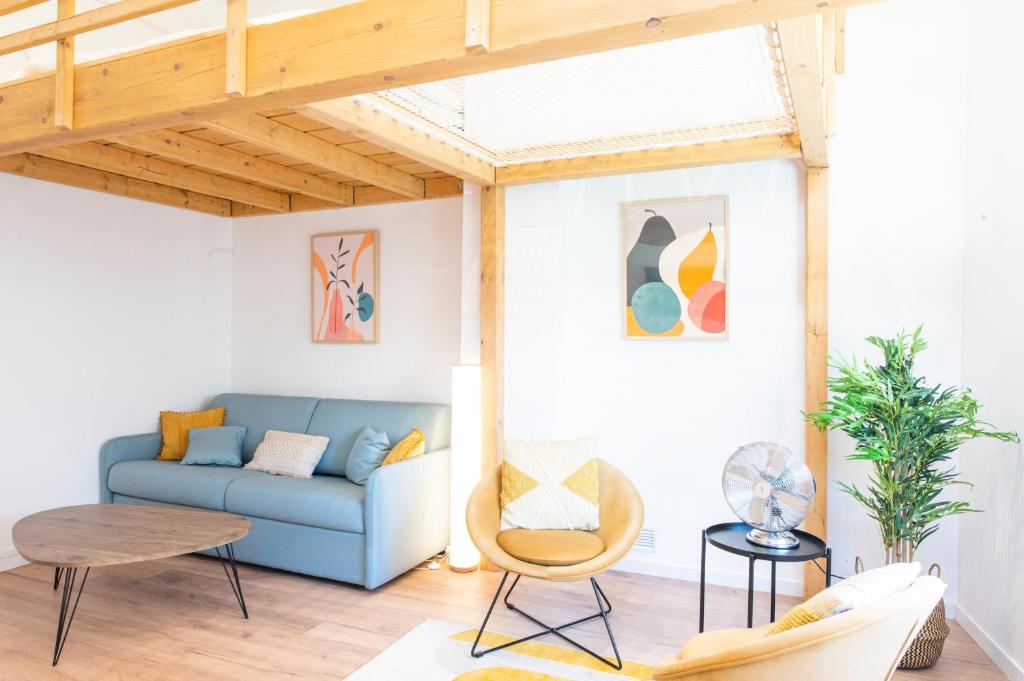 a living room with a blue couch and a table at Le haut perché in Colmar