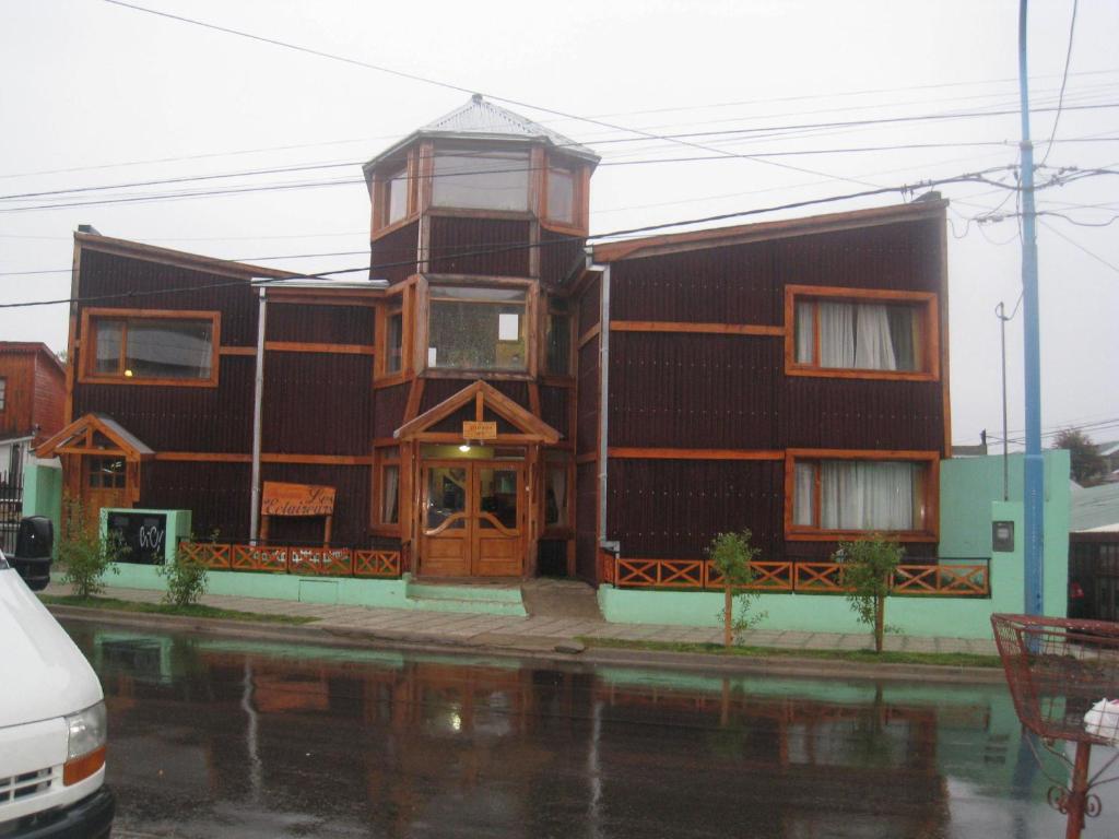 a building on a street with water in front of it at Hosteria Les Eclaireurs in Ushuaia