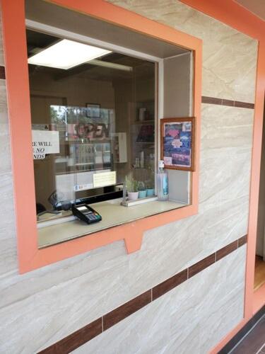 ein Fenster mit orangefarbenem Rahmen in einem Geschäft in der Unterkunft Ranch Motel in Roswell